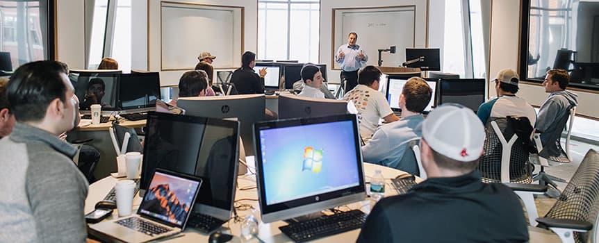 Picture of students interacting with professor in the Ryan Finance lab.